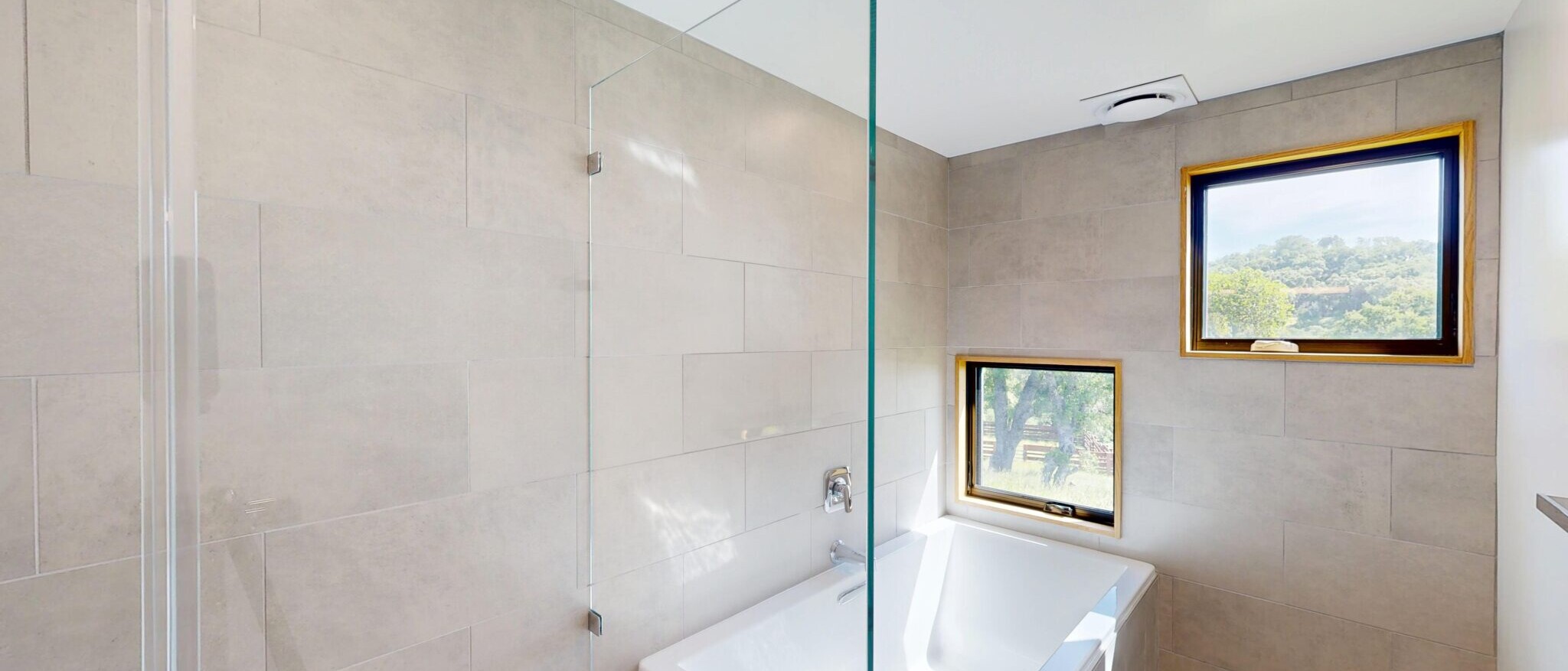 Modern bathroom with walk-in shower and separate built-in tub in a custom residential project by Black Creek Builders, featuring clean tile work and natural light.