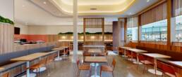 Modern restaurant interior with warm wood accents, banquette seating, and decorative screens, built by Black Creek Builders.