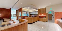 Modern restaurant interior with curved wood paneling, diverse seating, and service counter, built by Black Creek Builders.