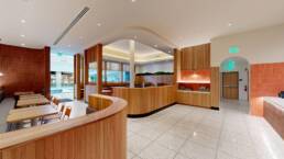 Modern restaurant interior with curved wood paneling, diverse seating, and service counter, built by Black Creek Builders.