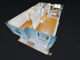 A Matterport 3D dollhouse view of a modern apartment, showcasing the full layout of the living room with hardwood floors, a kitchen with marble-like tiles, and other rooms like bathrooms and bedrooms, all visible from an aerial, cutaway perspective.