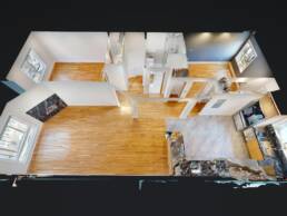 A Matterport 3D dollhouse view of a modern apartment, showcasing the full layout of the living room with hardwood floors, a kitchen with marble-like tiles, and other rooms like bathrooms and bedrooms, all visible from an aerial, cutaway perspective.